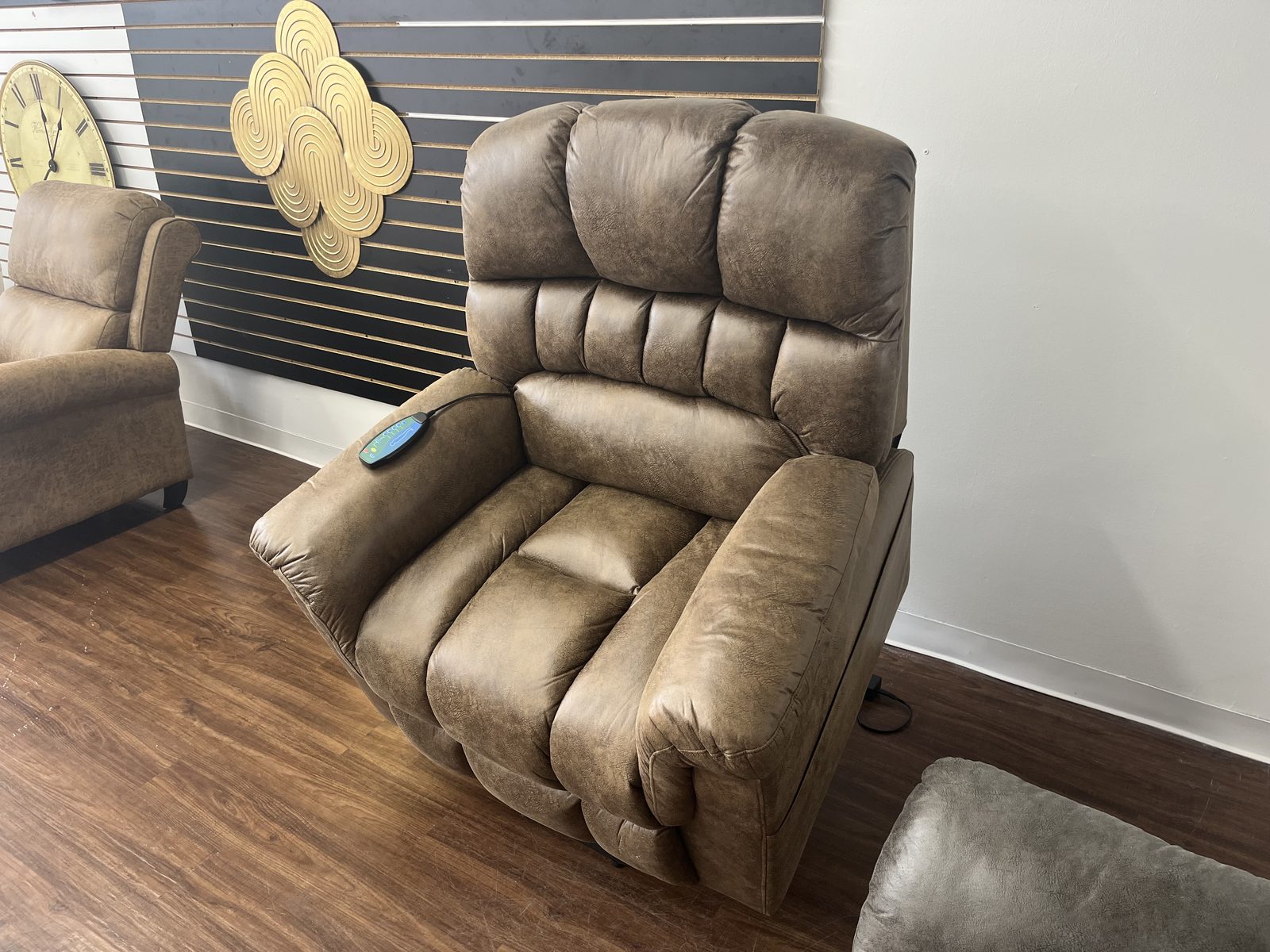 Tan power lift recliner on the Arts & Accents showroom floor, with a lit control pad on the armrest.